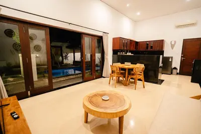 a living room with a table and a kitchen at Villa Kirari in Seminyak