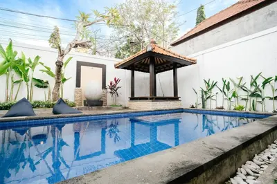 a swimming pool in front of a house with a gazebo at Villa Kirari in Seminyak