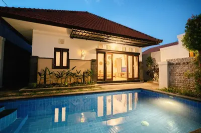 a swimming pool in front of a house at Villa Kirari in Seminyak