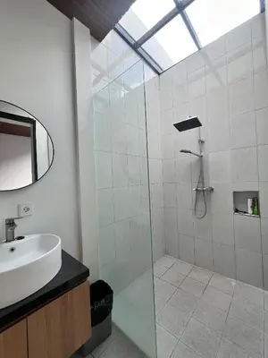 a bathroom with a glass shower and a sink at Oemah Ozzy Villa 2 Bedroom With Privat Pool in Seminyak