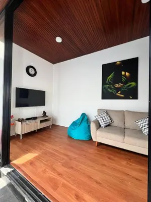 a living room with a couch and a tv at Oemah Ozzy Villa 2 Bedroom With Privat Pool in Seminyak