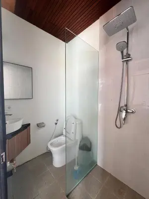 a bathroom with a toilet and a glass shower stall at Oemah Ozzy Villa 2 Bedroom With Privat Pool in Seminyak