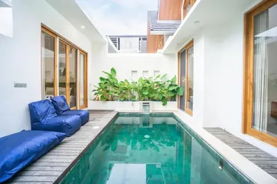 a swimming pool in a house with a blue couch at NEW! Spring Villa - 2BR Villa in Kerobokan in Kerobokan