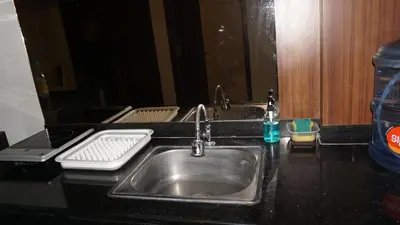 a kitchen counter with a sink and a mirror at Ambengan Tenten By BMI in Denpasar