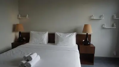 a bedroom with a bed with two towels on it at Ambengan Tenten By BMI in Denpasar