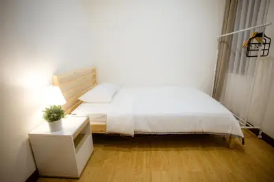 a small bedroom with a bed and a night stand at Jemma Home Warm & Simple 3BR Stay in Denpasar near Sanur in Pesanggaran