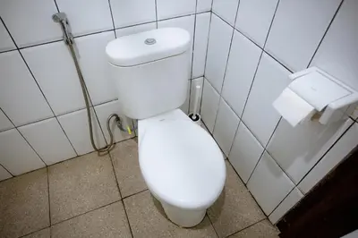 a white toilet in a bathroom with two rolls of toilet paper at Jemma Home Warm & Simple 3BR Stay in Denpasar near Sanur in Pesanggaran