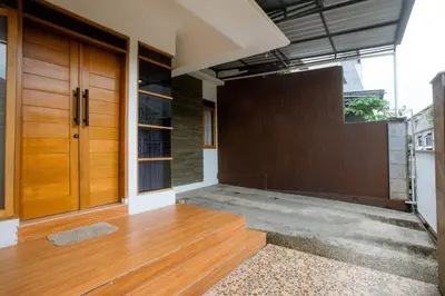 an empty house with wooden doors and wooden floors at Jemma Home Warm & Simple 3BR Stay in Denpasar near Sanur in Pesanggaran