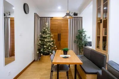 a christmas tree in a living room with a table at Jemma Home Warm & Simple 3BR Stay in Denpasar near Sanur in Pesanggaran