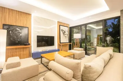 a living room with a couch and a tv at Luxury 3BR Modern Villa in the Heart of Seminyak in Seminyak