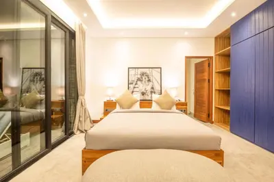 a bedroom with a large bed and glass walls at Luxury 3BR Modern Villa in the Heart of Seminyak in Seminyak
