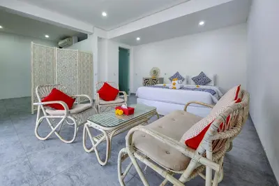 a bedroom with wicker chairs and a bed with red pillows at Emilia 1 Bedroom Apartment Seminyak by Nagisa Bali in Kerobokan