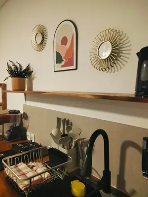 a kitchen counter with a sink and a mirror at Amshiga 2 in Jimbaran