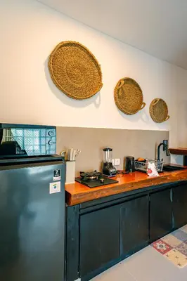 a kitchen with a refrigerator and baskets on the wall at Amshiga 6 in Jimbaran