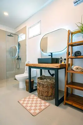 a bathroom with a vanity with a mirror and a toilet at Amshiga 6 in Jimbaran
