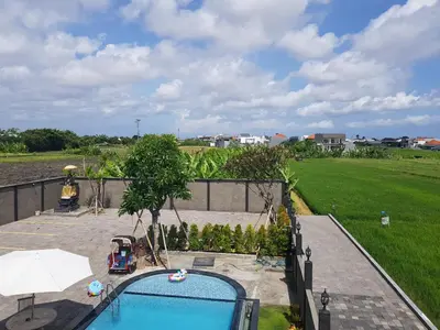 an overhead view of a swimming pool with an umbrella at Studio with rice field view in Kerobokan in Kerobokan