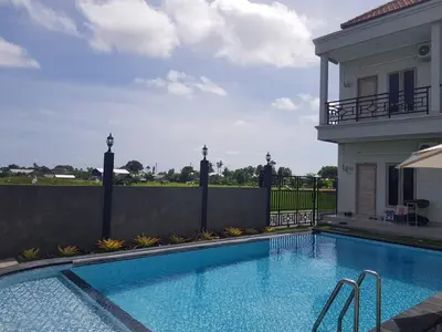a swimming pool in front of a house at Studio with rice field view in Kerobokan in Kerobokan