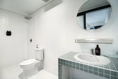 a bathroom with a toilet and a sink and a mirror at Berawa Nest by CPM Bali in Canggu