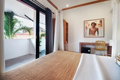 a bedroom with a large bed and a fireplace at Berawa Nest by CPM Bali in Canggu