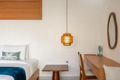 a bedroom with a bed and a wooden desk at Nirvana Villa by Betterplace in Seminyak