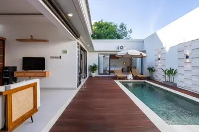 an indoor swimming pool in a house with a patio at Nirvana Villa by Betterplace in Seminyak