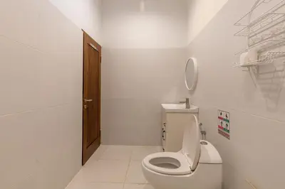 a white bathroom with a toilet and a sink at Soma Villa by Betterplace in Jimbaran