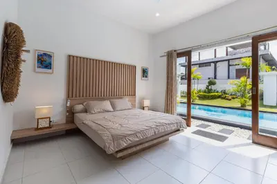 a bedroom with a bed and a swimming pool at Soma Villa by Betterplace in Jimbaran