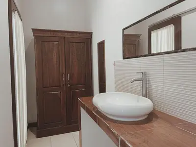 a bathroom with a white sink on a counter at Kubu Van Helen in Legian