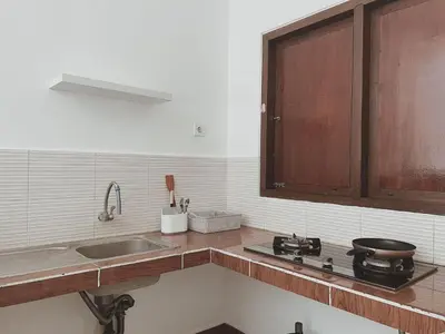 a kitchen with a sink and a stove top oven at Kubu Van Helen in Legian