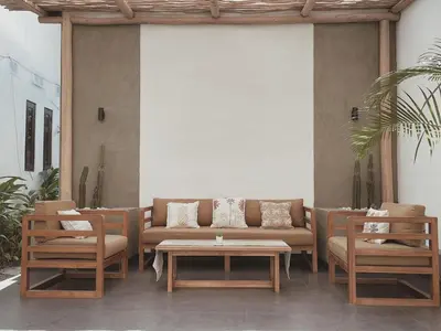 a patio with a couch and two chairs and a table at Kubu Van Helen in Legian