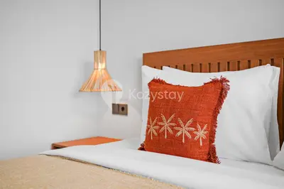 a bedroom with a bed with a pillow and a lamp at deTasia Villa by Kozystay - Jimbaran in Jimbaran