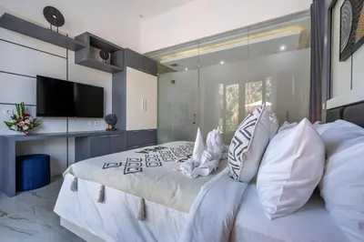 a bedroom with a large white bed with white pillows at Villa Naga by JB Villas in Seminyak