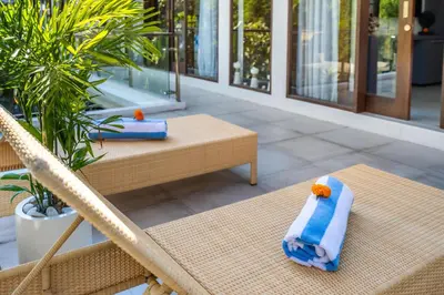 a pair of towels sitting on chairs on a patio at Villa Naga by JB Villas in Seminyak