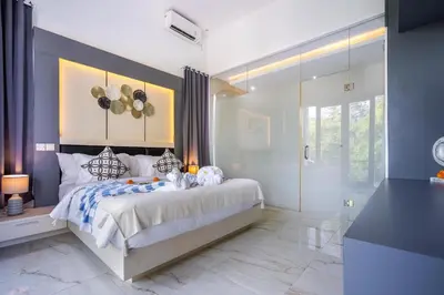 a bedroom with a bed and a walk in shower at Villa Naga by JB Villas in Seminyak