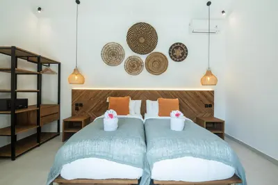 a bedroom with two beds and two baskets on the wall at Villa ADDI 4bedrooms Oberoi in Seminyak