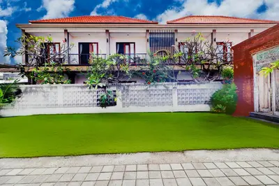 a house with a green lawn in front of it at Collection O Bali Sanur near Bali Mandara Hospital in Sanur