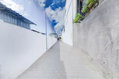 an alleyway between two white buildings with a blue sky at Collection O Bali Sanur near Bali Mandara Hospital in Sanur