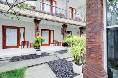 a courtyard of a house with chairs and plants at Collection O Bali Sanur near Bali Mandara Hospital in Sanur