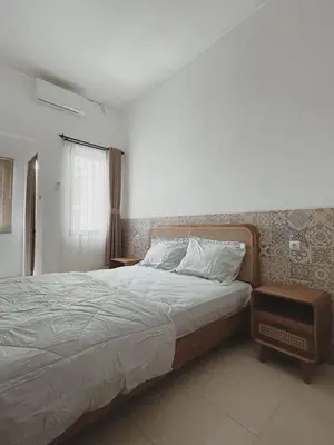 a bedroom with a large bed and a window at Sukanadi's Homestay in Legian