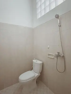 a bathroom with a toilet and a shower at Sukanadi's Homestay in Legian