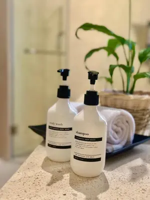 two bottles of laundry detergent sitting on a bathroom counter at Villa Vela in the heart of Seminyak in Seminyak