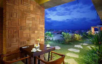 a table and chairs on a patio with a view at The Visala Boutique Suites Seminyak in Seminyak