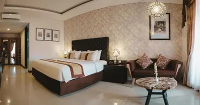a bedroom with a large bed and a chair at The Visala Boutique Suites Seminyak in Seminyak