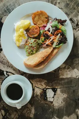 a plate of food with a sandwich and a cup of coffee at The Visala Boutique Suites Seminyak in Seminyak