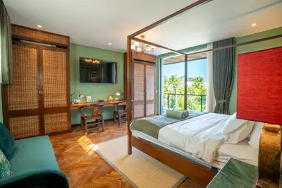 a bedroom with a bed and a desk in a room at Dreamtime House Bali in Canggu