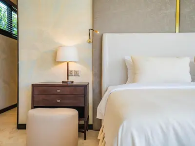 a bedroom with a bed and a table with a lamp at Dreamtime House Bali in Canggu