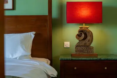 a lamp sitting on a table next to a bed at Dreamtime House Bali in Canggu