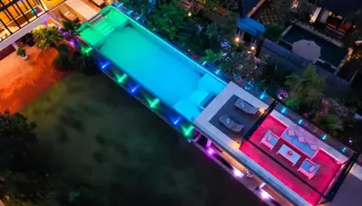 an overhead view of a swimming pool at night with lights at Lillypad 5Bed Villa in Seminyak