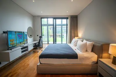 a bedroom with a large bed and a television at Lillypad 5Bed Villa in Seminyak