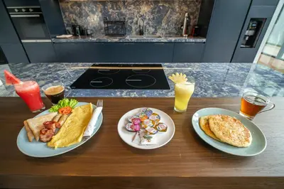 a table with two plates of food and two drinks at Lillypad 5Bed Villa in Seminyak